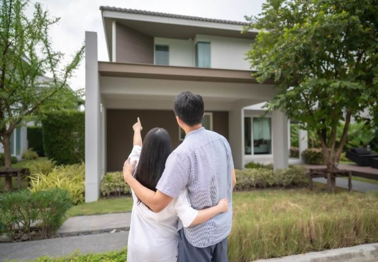 A couple standing in front of a modern house, symbolizing hope for homeownership after bankruptcy in Australia.