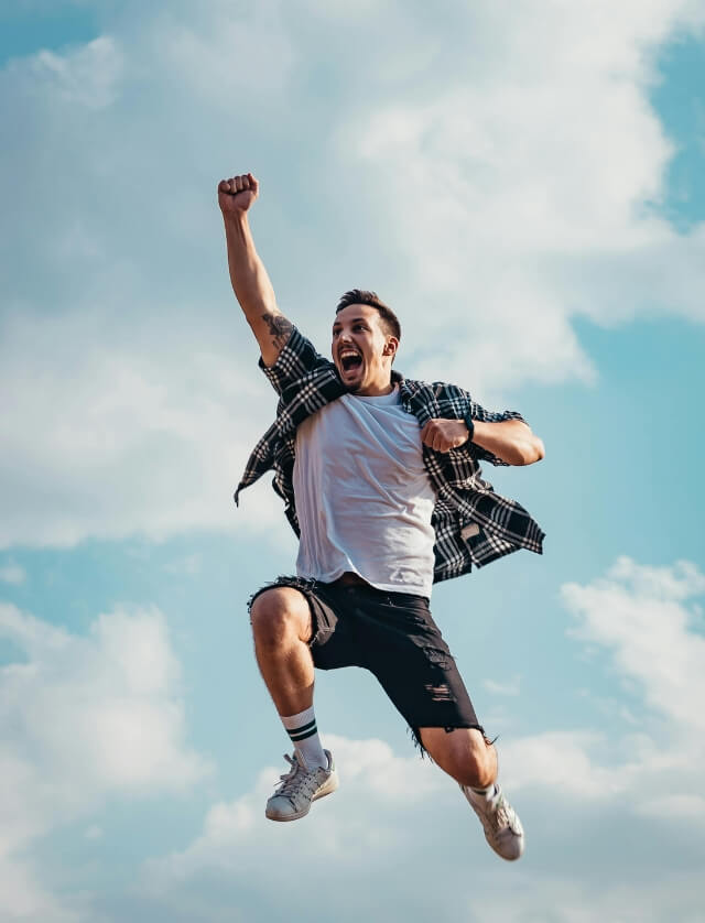 A smiling person jumps joyfully outdoors, representing the relief of securing a Centrelink loan.