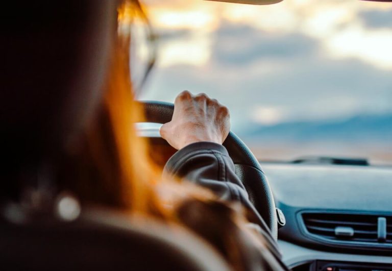 Person test driving a used car at sunset — an important step in choosing the right vehicle.
