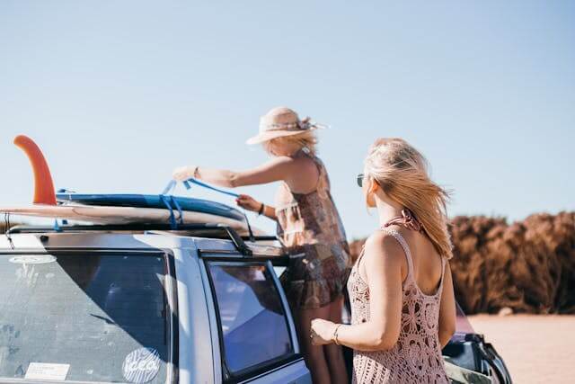 Family loading surfboards onto a car at the beach — enjoying freedom with car finance despite bad credit in Australia.