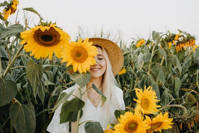 Woman smiling in a sunflower field, symbolising optimism and a fresh start despite past credit challenges.