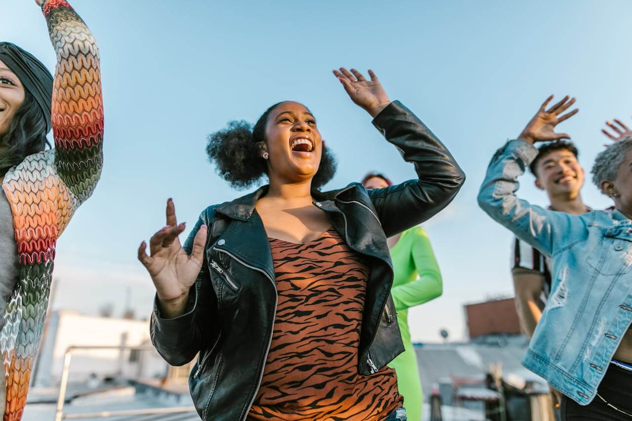 People celebrating outdoors, representing positive financial progress and relief