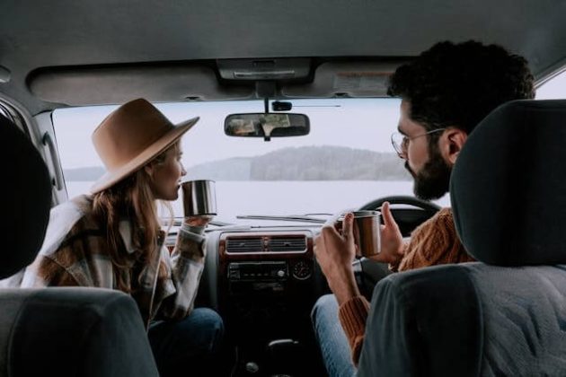 Couple driving together in a car, looking relaxed — symbolising freedom.